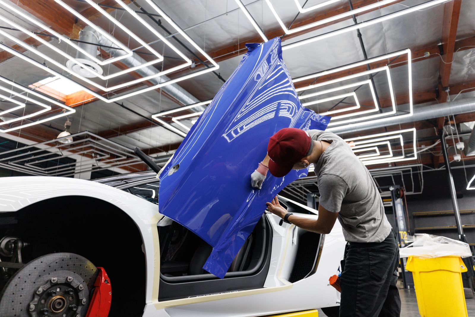Mechanic working on a car door in a garage