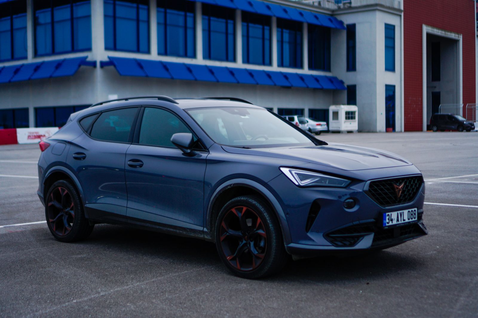 Blue SUV parked outside a modern office building
