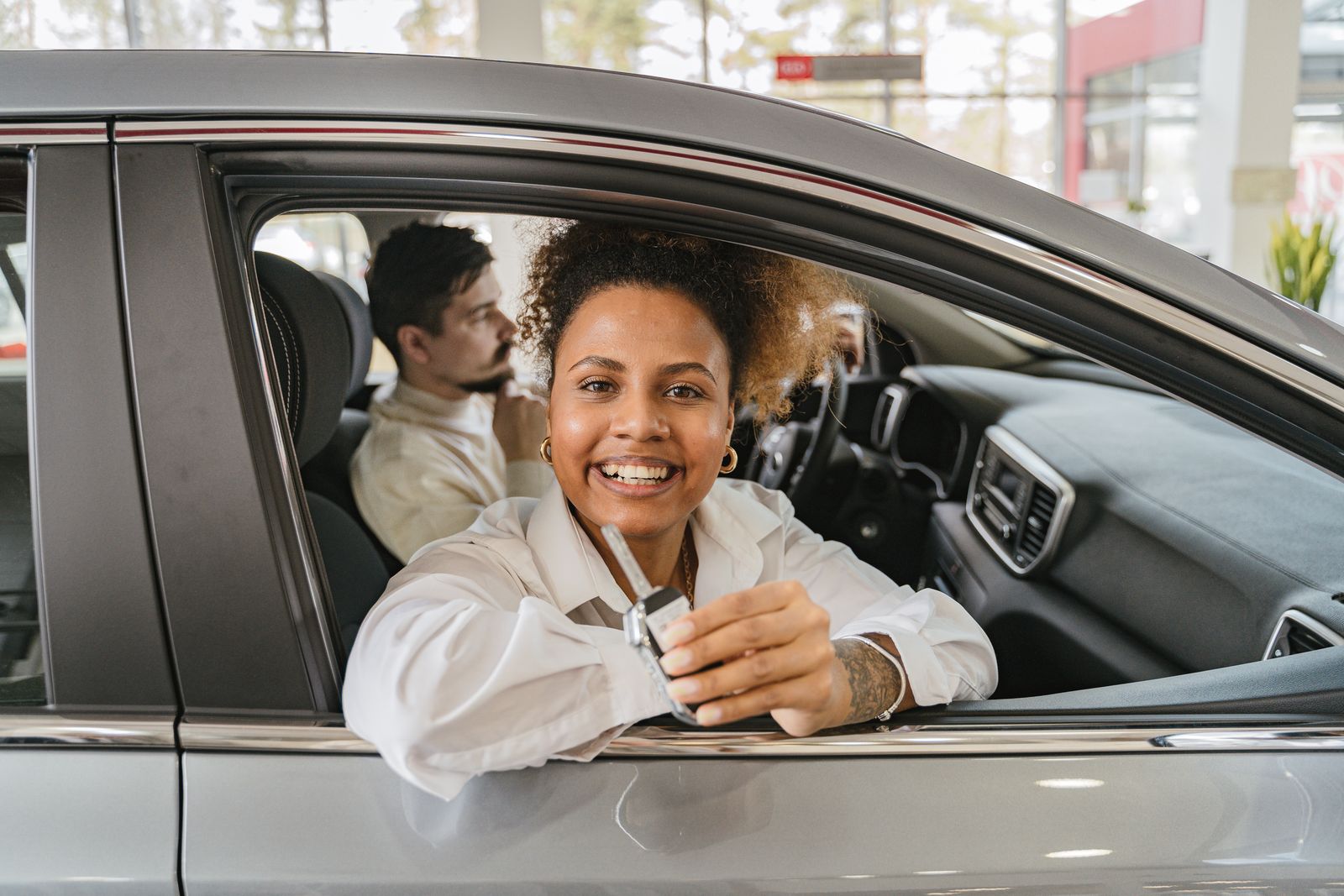 Customers receiving car keys at a dealership counter