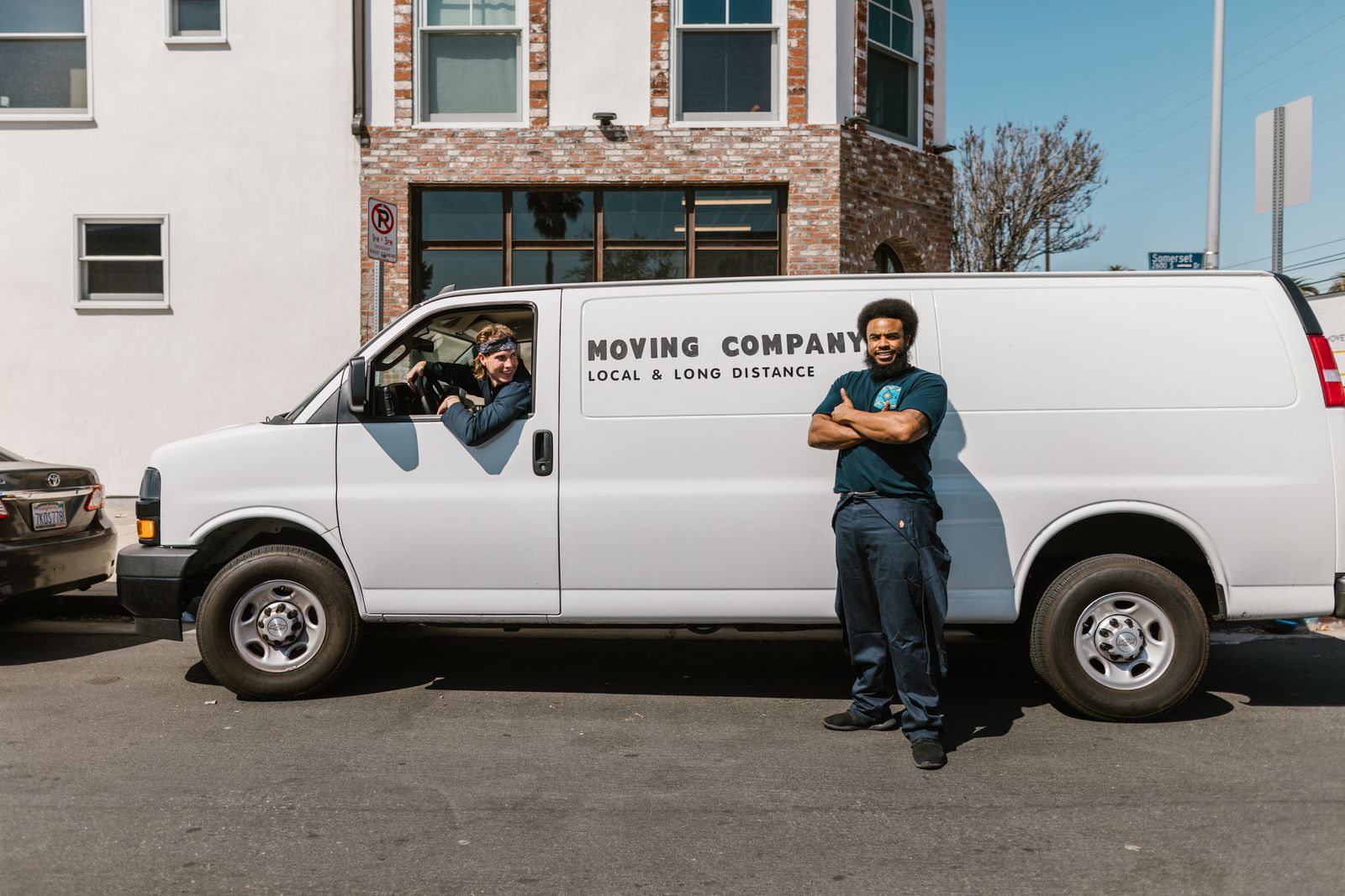 Moving crew standing beside a rental van on a city street